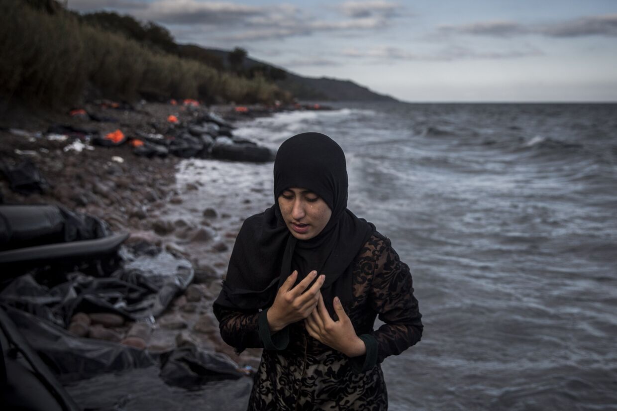 Женщина, прибывшая на греческий остров Лесбос на резиновой лодке из Турции