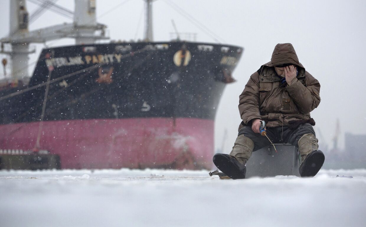Рыбак на фоне корабля в Санкт-Петербурге