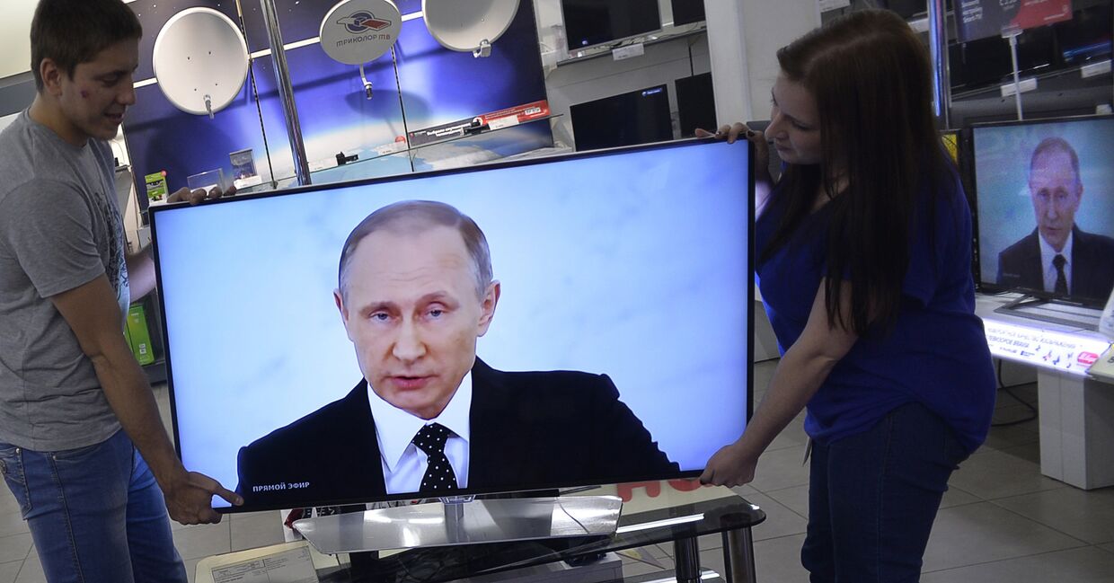 Работники магазина электроники в Москве устанавливают телевизор