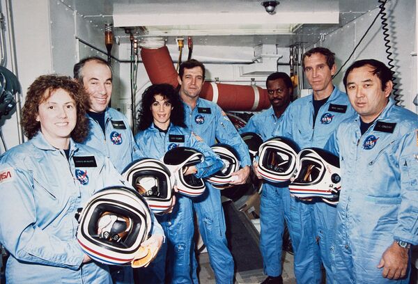 Экипаж STS-51L. Слева направо: Маколифф, Джарвис, Резник, Скоби, МакНейр, Смит, Онидзука Экипаж STS-51L. Слева направо: Маколифф, Джарвис, Резник, Скоби, МакНейр, Смит, Онидзука