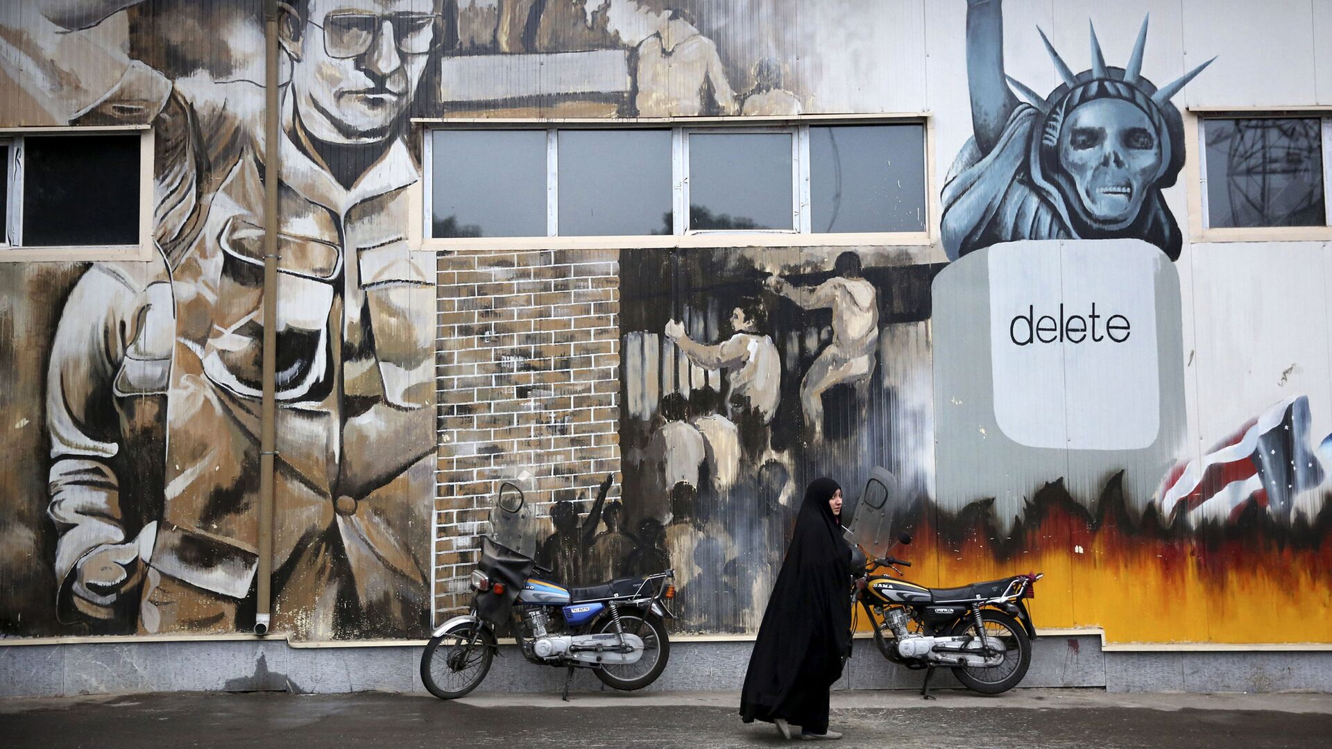 Женщина на фоне граффити на стенах бывшего посольства США в Тегеране, Иран - ИноСМИ, 1920, 30.06.2023