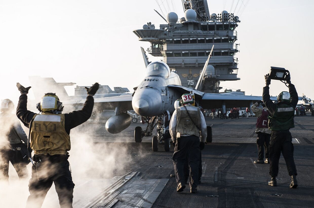 Моряки направляют истребитель F/A-18C Hornet на взлетную полосу авианосца «Гарри Трумэн»