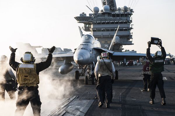Моряки направляют истребитель F/A-18C Hornet на взлетную полосу авианосца «Гарри Трумэн» Моряки направляют истребитель F/A-18C Hornet на взлетную полосу авианосца «Гарри Трумэн»