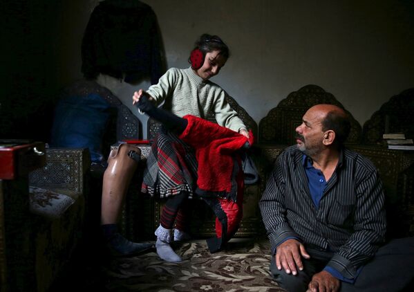 Инвалид Шахрур с дочерью у себя дома, Ирбин, Сирия
