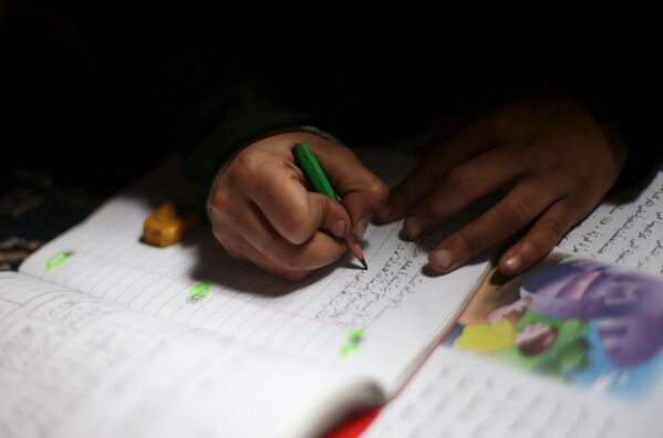 Дочка сирийского инвалида Шахрура делает домашнюю работу
