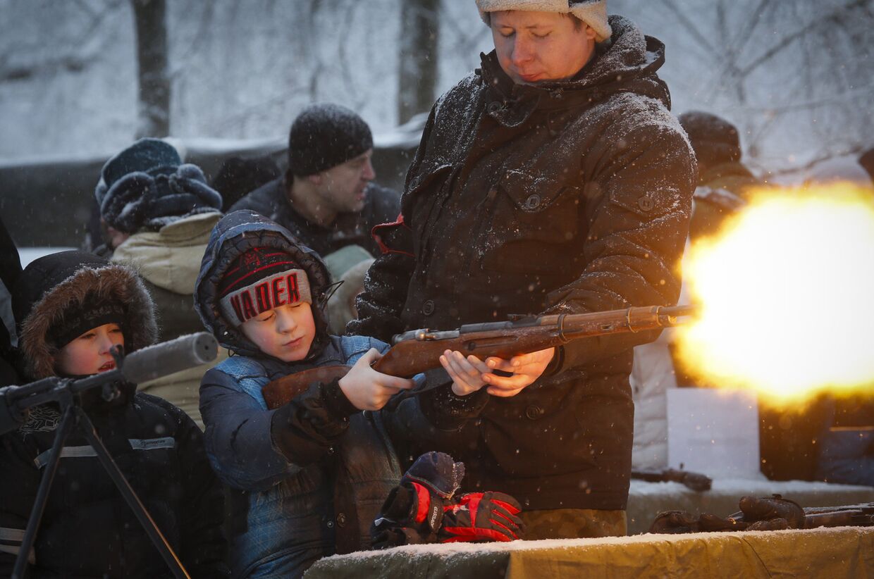 Мальчик стреляет из винтовки во время оружейной выставки в Санкт-Петербурге