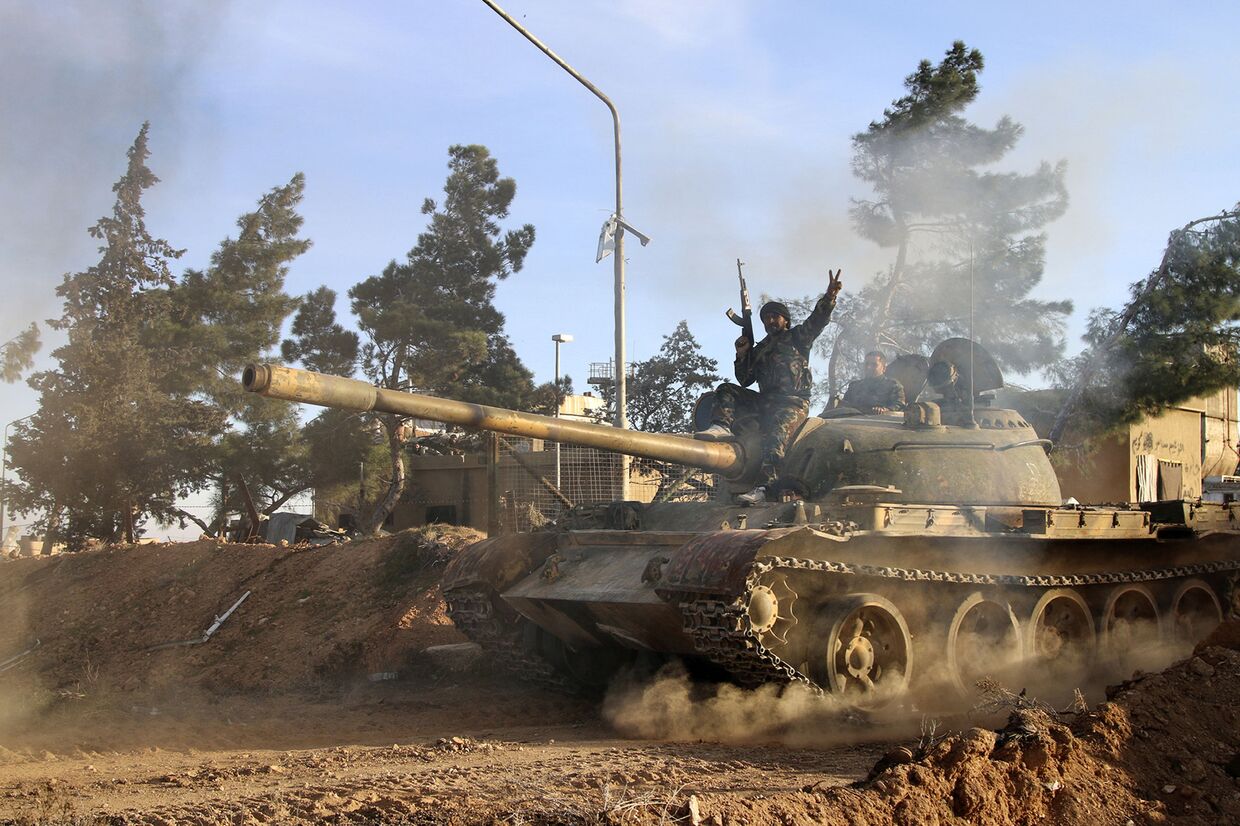 Доброволец, сражающийся на стороне сирийской армии едет на танке в городе Рекка