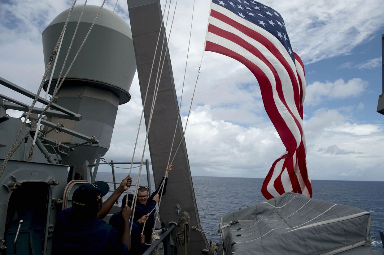 Американские матросы поднимают национальный флаг во время учений в Южно-Китайском море