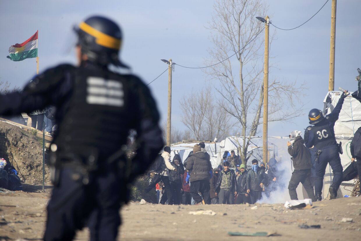 Сотрудники полиции во время беспорядков в лагере мигрантов Джунгли возле Кале, Франция