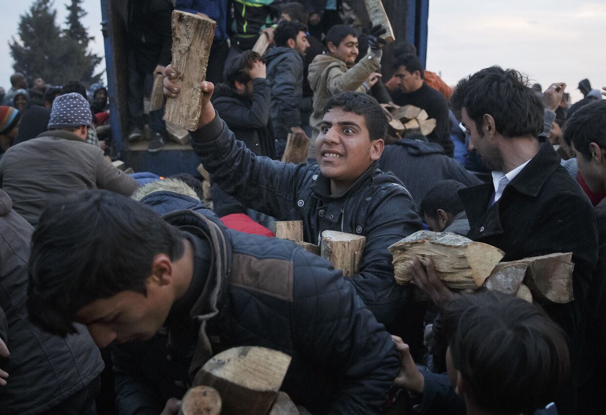Беженцы запасаются дровами во временном лагере на границе Греции и Македонии