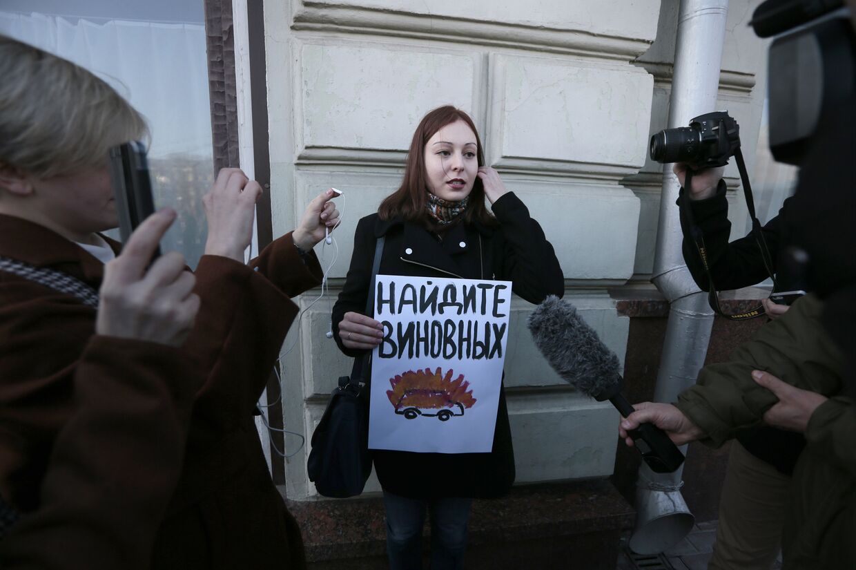 Активист отстаивающий права человека с плакатом, призывающим найти виновных в инциденте с нападением на журналистов