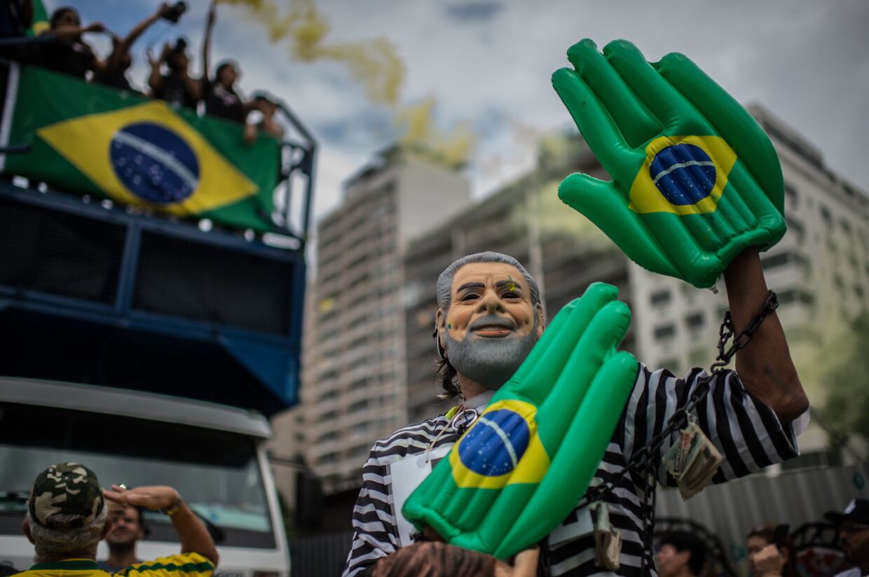 Участник демонстрации против президента Бразилии Дилмы Роуссефф в маске экс-президента Лулу да Силва в Рио-де-Жанейро