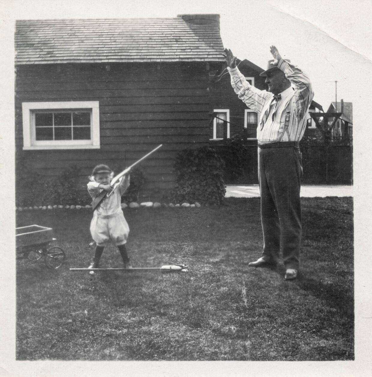 Ребенок целится из ружья в своего дедушку