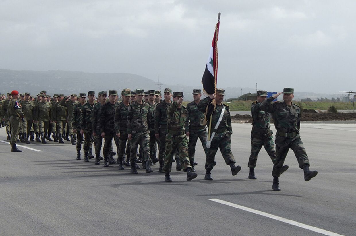 Солдаты сирийской армии маршируют на церемонии прощания с российскими военными на базе Хмеймим в Сирии