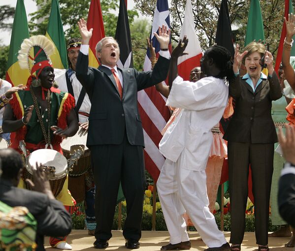 Бывший президент США Джордж Буш вместе со своей женой танцуют восточно-африканские танцы