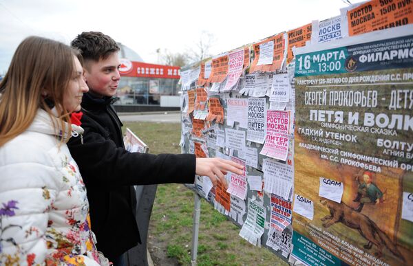 Юные жители города читают объявления на уличном стенде в Донецке Юные жители города читают объявления на уличном стенде в Донецке