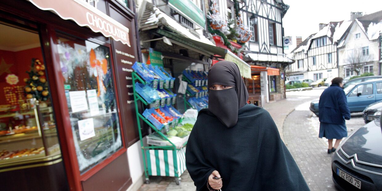 Девушка в мусульманской одежде на улице Ле Мениль-Сен-Дени, Франция