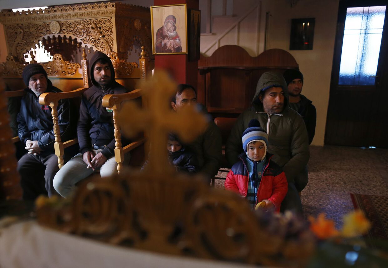 Сирийские беженцы-католики на службе в православной церкви в деревне Идомени, Греция
