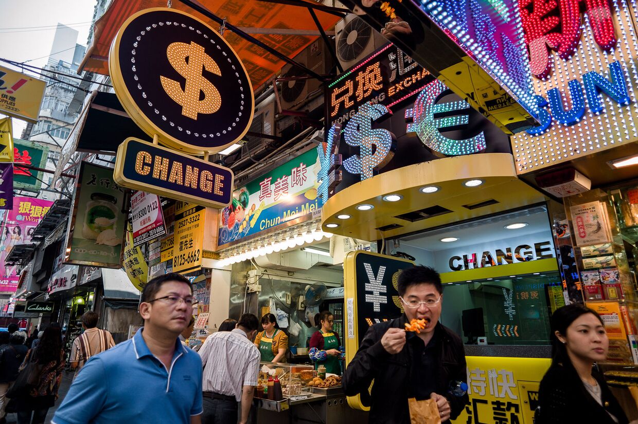 Прохожие гуляют мимо обменных пунктов в Гонконге