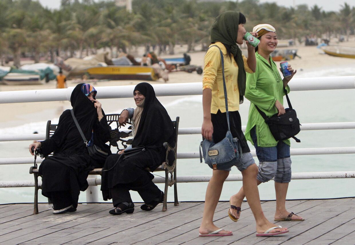 Туристки из Китая гуляют по набережной на Острове Киш в Иране