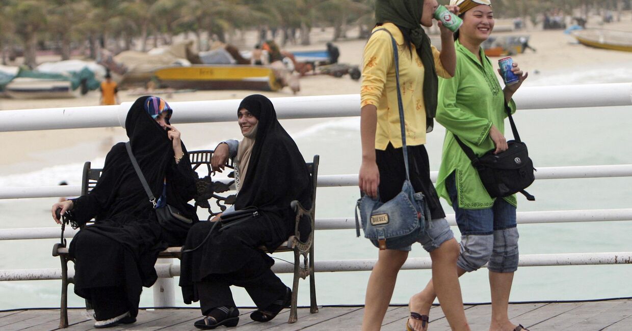 Туристки из Китая гуляют по набережной на Острове Киш в Иране