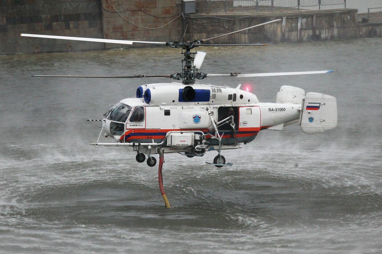 Пожарный вертолет КА-32А набирает воду из реки Москвы