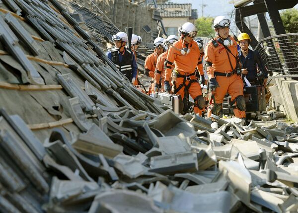 Пожарные среди разрушенных в результате землетрясения зданий. Кумамото, Япония. Апрель 2016
