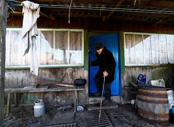 Житель зоны отчуждения Чернобыльской АЭС возле своего дома