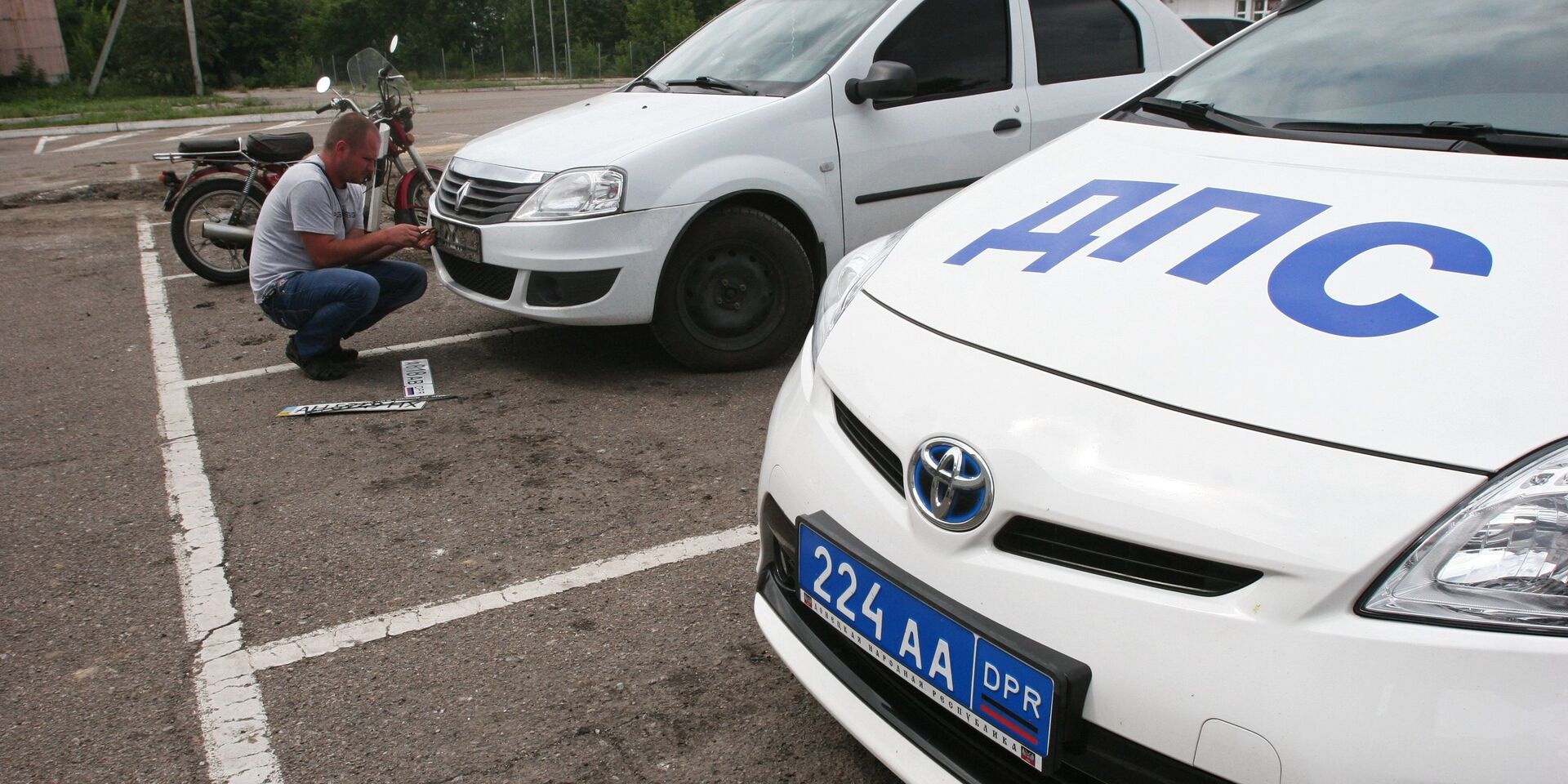 Мужчина устанавливает номерной регистрационный знак Донецкой народной республики на автомобиль в Донецке - ИноСМИ, 1920, 23.11.2022