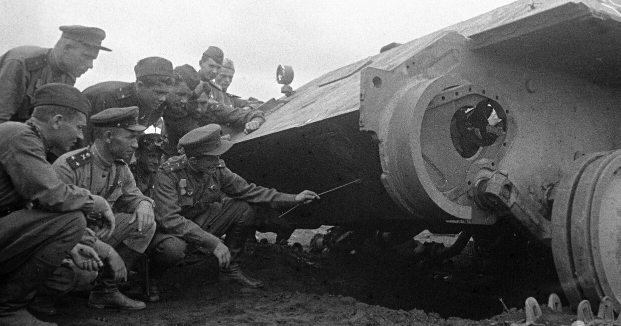 Июль 1943 года. Артиллеристы изучают новую технику противника, подбитую ими на поле боя на Курской дуге.