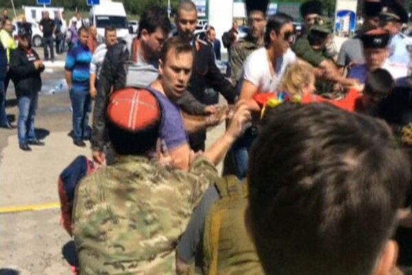 Российский оппозиционер Алексей Навальный и его сторонники во время стычки с казаками