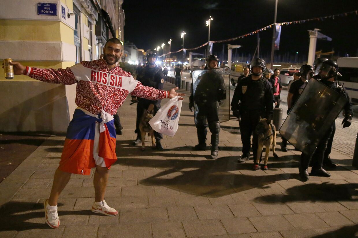 Российский болельщик возле полицейских на одной из улиц Марселя после окончания матча группового этапа чемпионата Европы по футболу — 2016 между сборными командами Англии и России