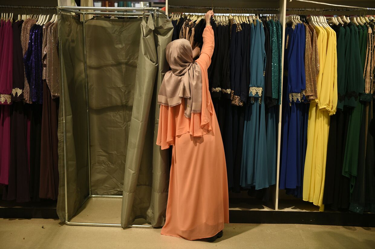 Женщина выбирает платье на 33-ей ежегодной встрече французских мусульман