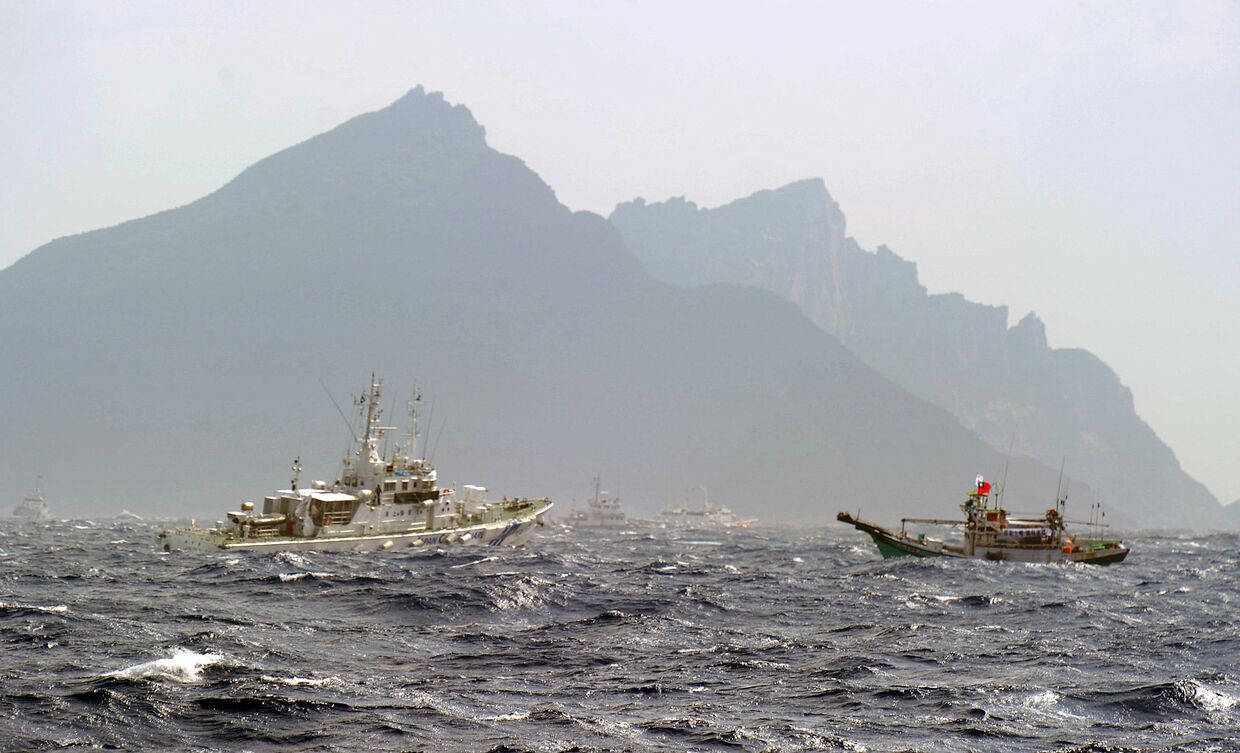 Тайваньская рыбацкая лодка и корабль береговой охраны Японии в районе островов Сенкаку в Восточно-Китайском море