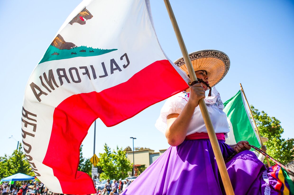 Женщина с флагом Республики Калифорния на параде в городе Аламида