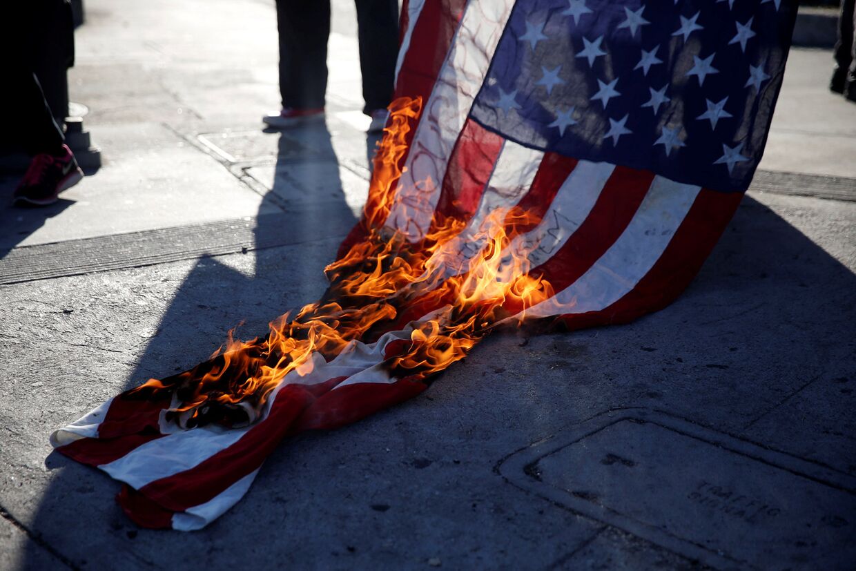 Активисты сжигают флаг во время акции протеста против произвола полиции
