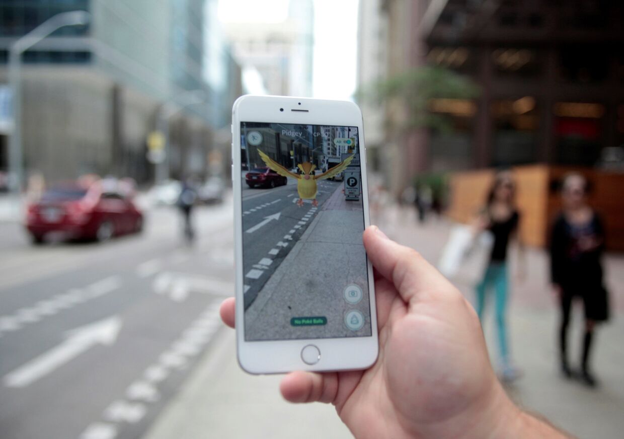 Мобильная игра Pokemon GO на экране смартфона в центре Торонто