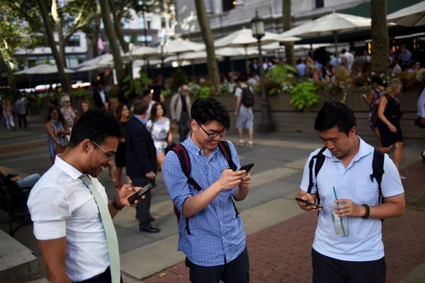 Люди играют в Pokemon GO на своих смартфонах в парке Брайант в Нью-Йорке Люди играют в Pokemon GO на своих смартфонах в парке Брайант в Нью-Йорке