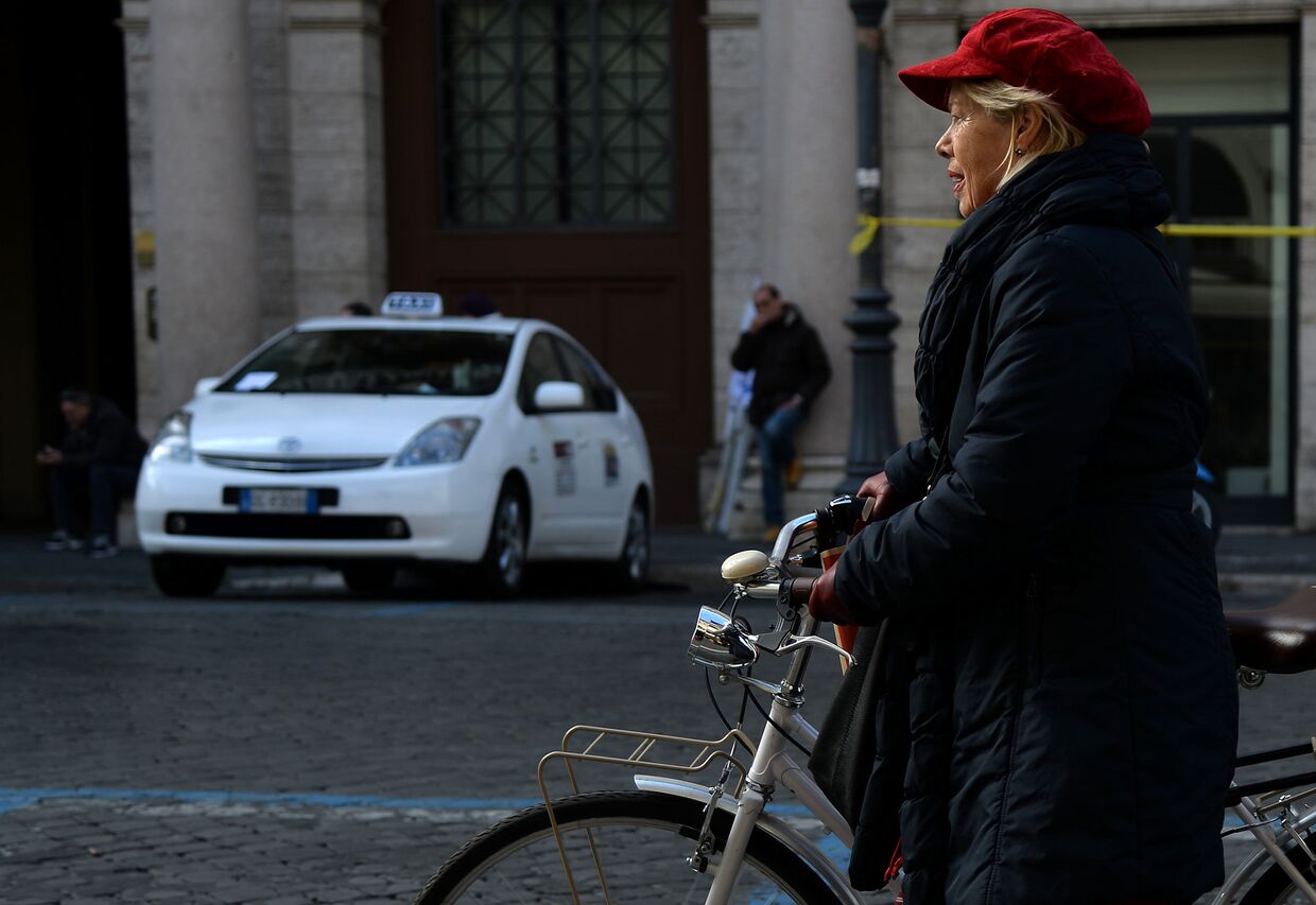 Женщина пользуется велосипедом во время акции протеста таксистов в центре Рима