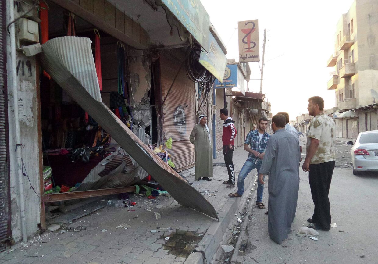 Жители города Ракка осматривают разрушенный магазин после падения беспилотника