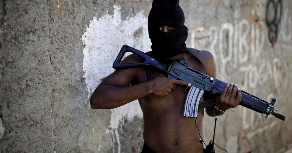 Наркоторговец в переулке трущоб в западной части Рио-де-Жанейро