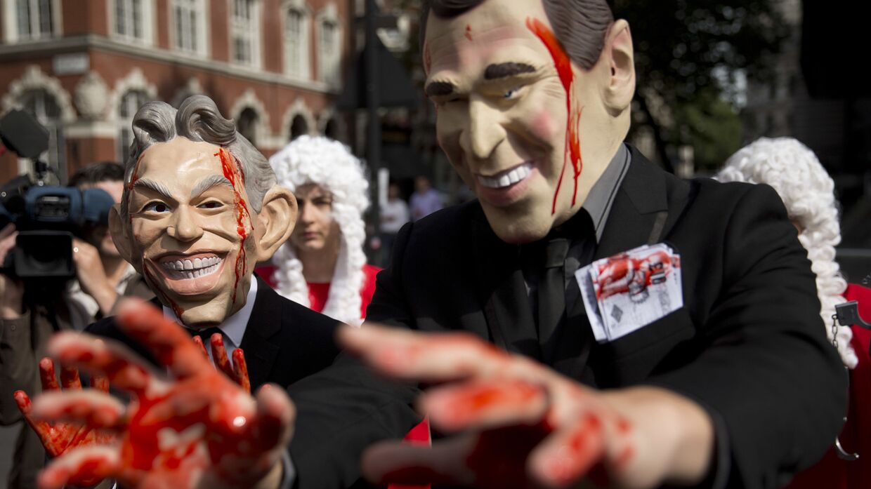 Демонстранты в масках бывшего премьер-министра Великобритании Тони Блэра и экс-президента США Джорджа Буша
