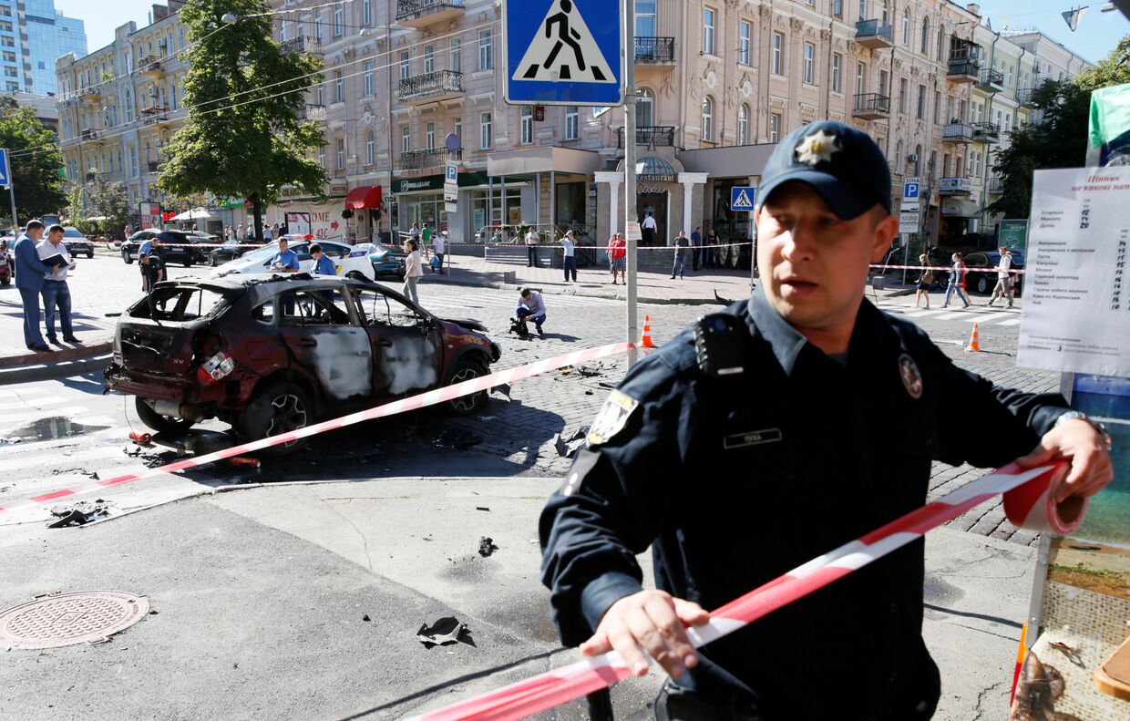Сотрудник правоохранительных органов на месте взрыва автомобиля, в результате которого погиб журналист Павел Шеремет