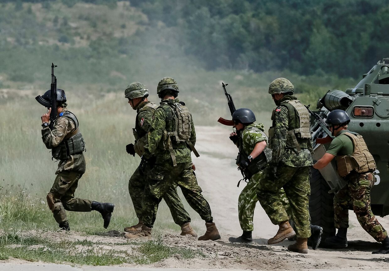 Военные инструкторы из Канады и украинские военнослужащие во время военных учений