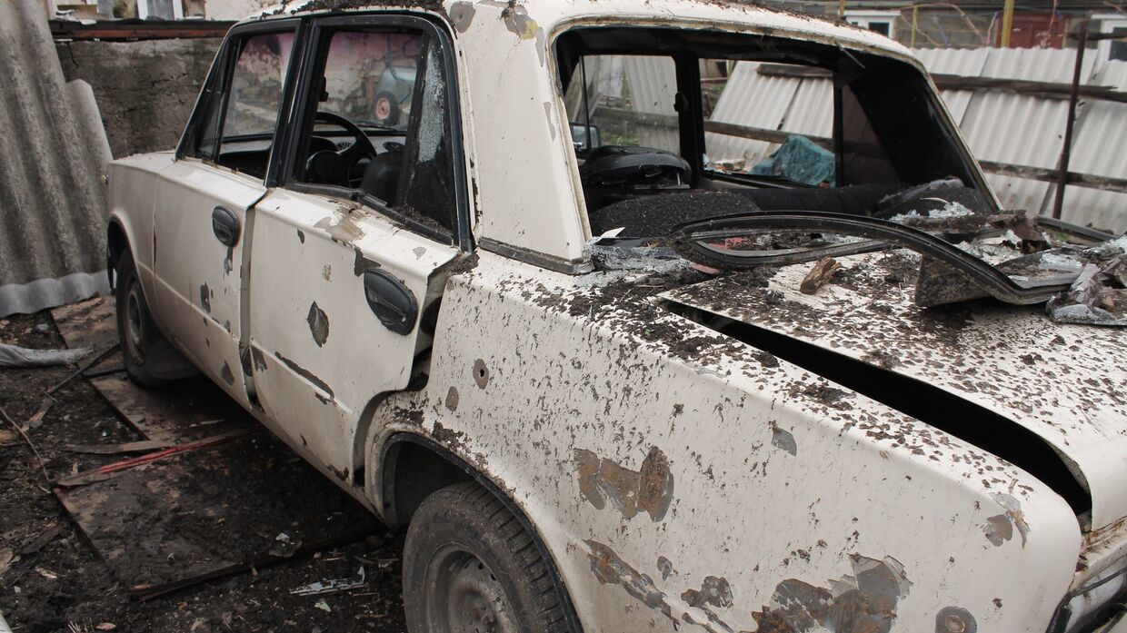Автомобиль во дворе жилого дома, пострадавший в результате обстрела украинскими силовиками, в Макеевке