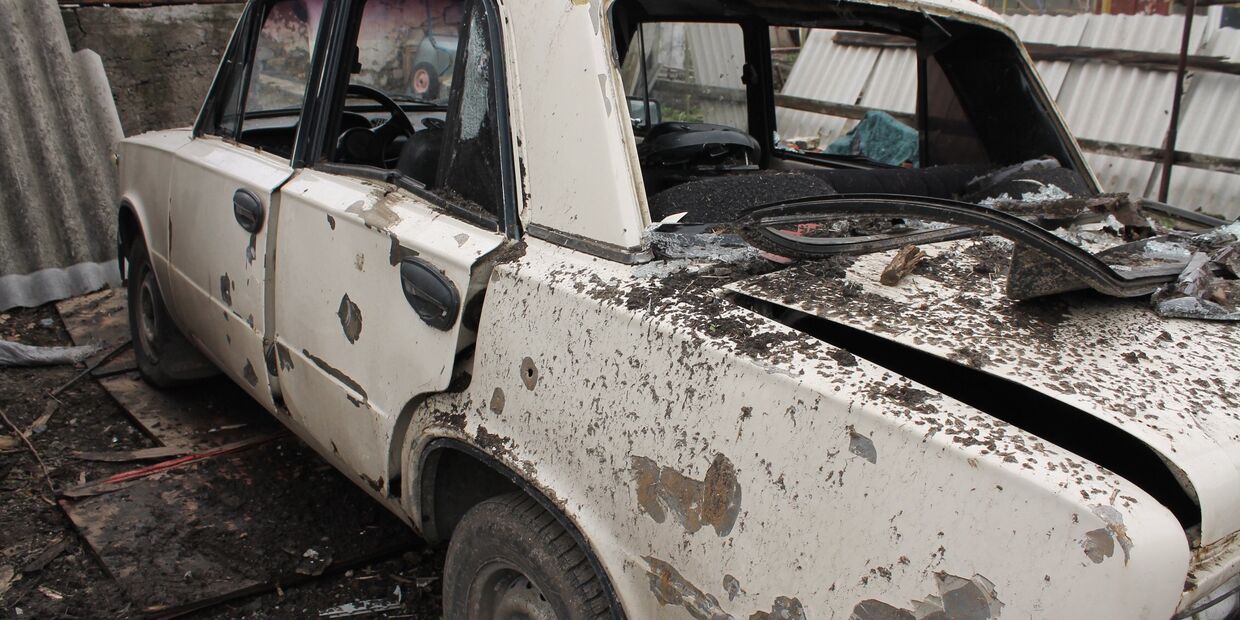 Автомобиль во дворе жилого дома, пострадавший в результате обстрела украинскими силовиками, в Макеевке