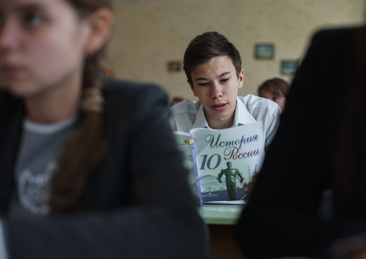 Ученик читает учебник по истории России в одной из школ Донецка