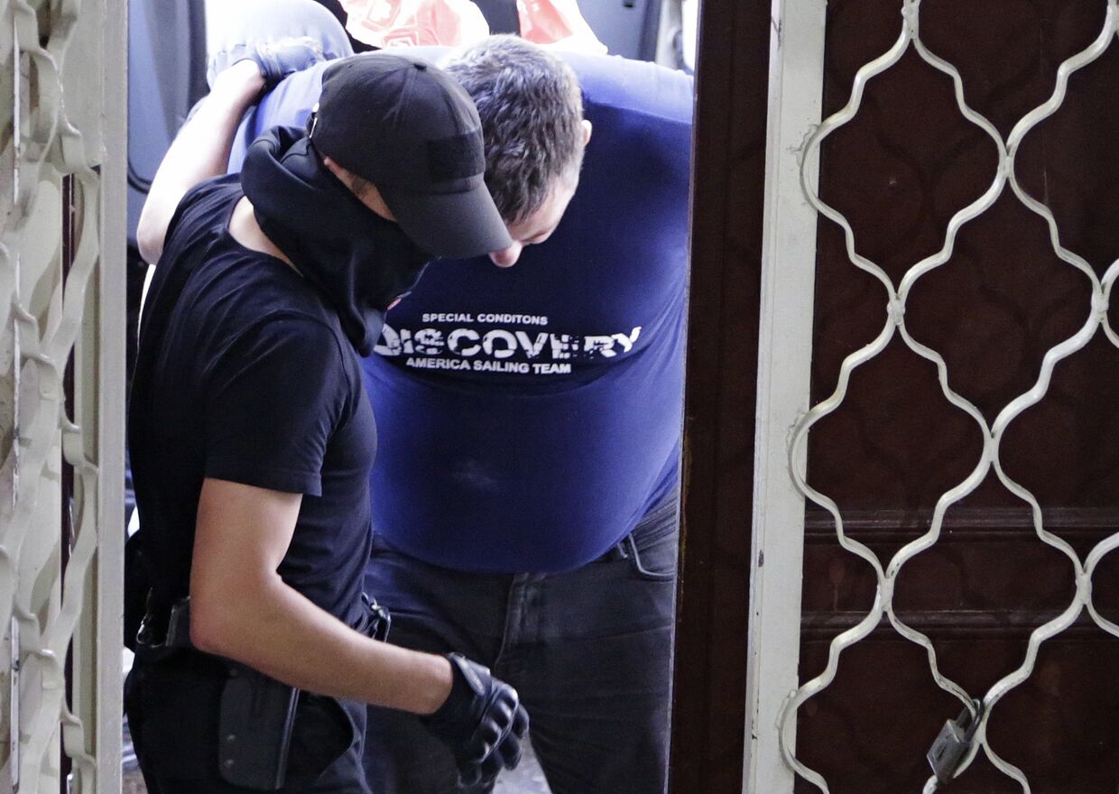 Сотрудники ФСБ вводят в Киевский районный суд Симферополя подозреваемого в организации терактов в Крыму Евгения Панова