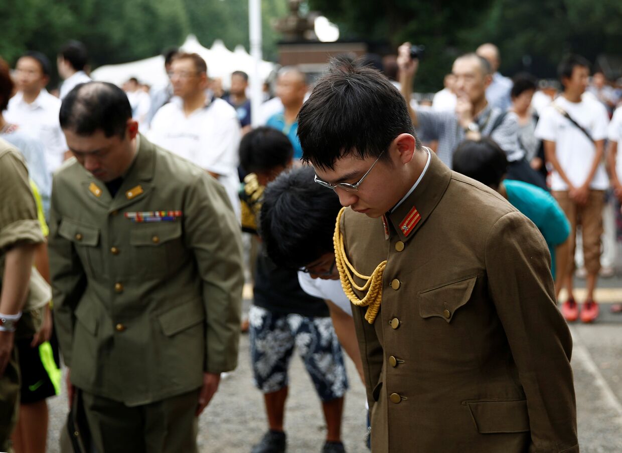 Японцы в форме Второй мировой войны во время минуты молчания в храме Ясукуни на церемонии, посвященной годовщине капитуляции