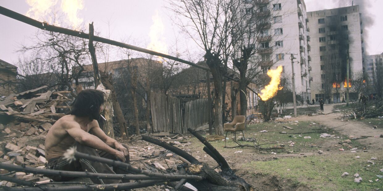 Житель Грозного смотрит на горящие дома